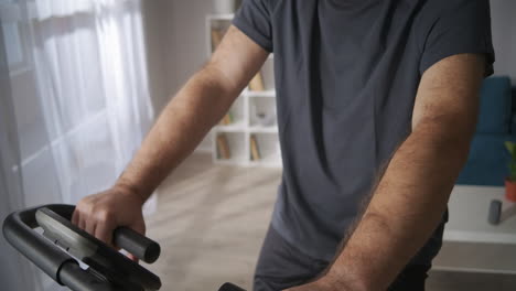 middle-aged-man-is-training-on-exercise-bicycle-at-home-healthy-lifestyle-keeping-good-physical-condition-at-middle-age